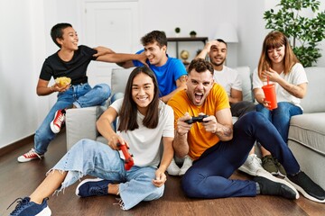 Obraz premium Group of young friends smiling happy playing video game at home.