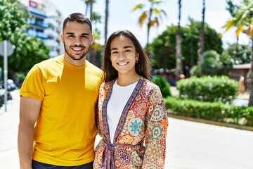 Naklejka premium Young latin couple smiling happy and hugging at the city.