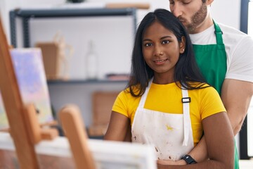 Man and woman artist couple hugging each other drawing at art studio