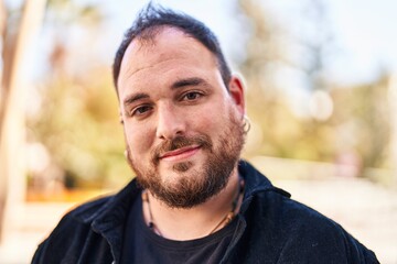 Young hispanic man smiling confident standing at park