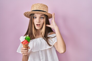 Teenager girl holding ice cream crazy and scared with hands on head, afraid and surprised of shock with open mouth