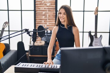 Adorable girl musician singing song playing piano keyboard at music studio