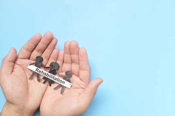 Hand holding black children paper cutout. Child abuse rehabilitation, custody, human rights and refugee care and protection concept.	