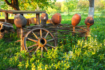 Clay pots, old folk dishes, are dressed on a wicker - an old light fence. A traditional element of architecture and rural life. in Ukraine