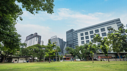 Apas, Cebu City, Philippines - An open field area with trees and standalone restaurants with BPO Office towers at the back. At Cebu IT Park. - obrazy, fototapety, plakaty