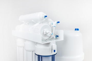 White and blue water filtration osmosis system with a carbon filter for clear water shot on a white background