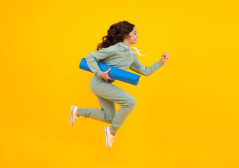 Fototapeta na wymiar Amazed teen girl. Teen girl 12, 13, 14 years old in sport suit. Fashion child in sportswear sportive clothing. Sportive fashionable outfit. Studio shot on yellow background. Run and jump.