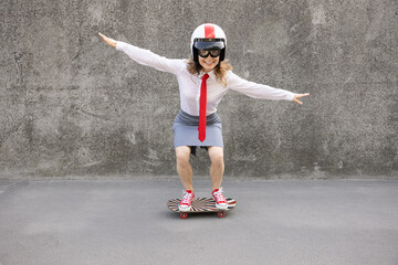 Funny businesswoman riding skateboard outdoor