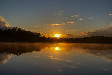 Obraz premium fog over lake water surface at sunset in summer