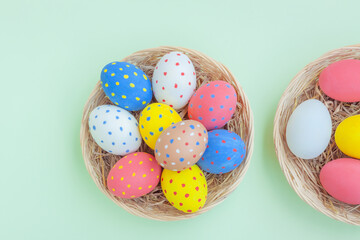 Colorful eggs in a basket on green background