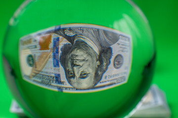 Close up view of crystal ball with inverted image of 100 dollars bill. Sweden.