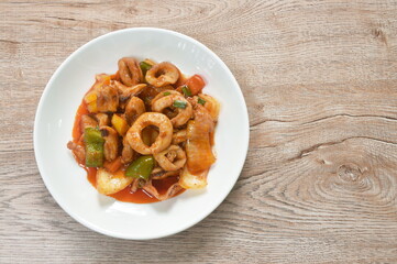fried squid with slice bell pepper and onion with sweet and sour sauce on plate 