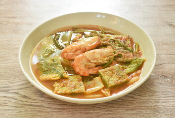 boiled shrimp and fried egg stuffed climbing wattle vegetable in spicy sour soup on plate 
