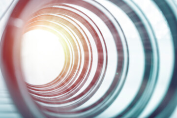 A large spiral tunnel with a shining reflection of the sun. Abstract, blurred background. copy space for text