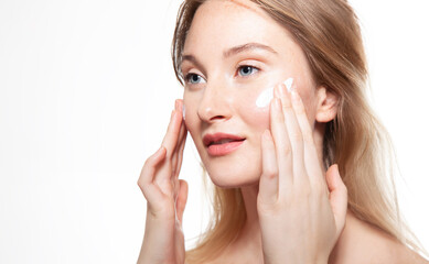 Obraz na płótnie Canvas Young woman applies moisturizer to protect delicate skin. Beauty portrait on white background