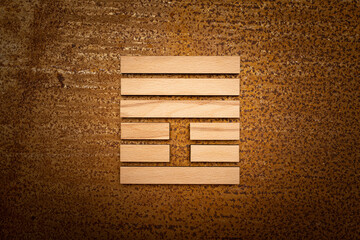 wooden Gene Key 25 i ging hexagram on rusty metal background human design