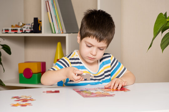 A preschooler plays puzzles, puts together a picture