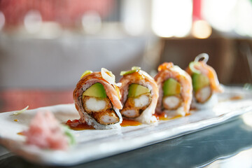Uramaki de salmón y langostino en tempura. Comida japonesa en un restaurante. Sushi roll