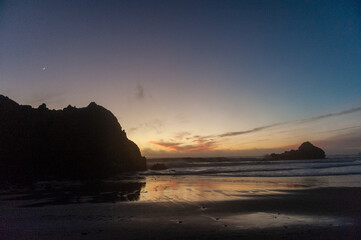 Bright orange clouds lit by the setting sun are relected in the retreating waters at Pfeiffer Beach.