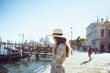 relaxed trendy woman in floral dress enjoying promenade