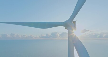 Aerial view Close up wind turbines for energy production with blue sunny sky. Drone flies over a windmill farm generating clean renewable energy for sustainable development green ecological world.