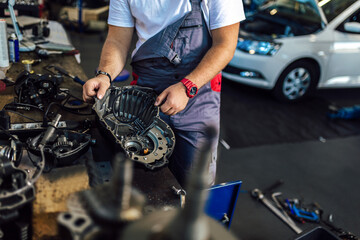 Technician working on checking and service car in workshop garage; technician repair and maintenance engine of automobile in car service