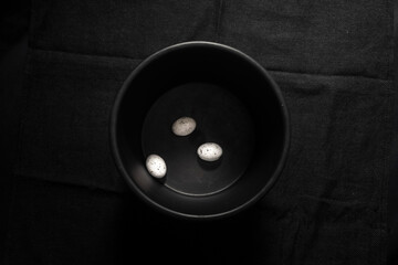 3 Eier in schwarzer Schale auf dunklem Hintergrund bei minimalen Licht