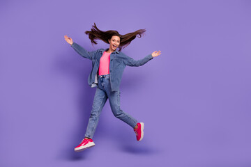 Full size portrait of overjoyed satisfied person jumping raise hands flying hair isolated on purple color background