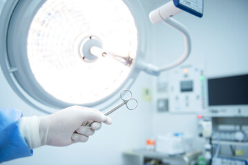 Fototapeta premium A team of Asian surgeons hand out surgical tools to other doctors while operating patients. Life-saving medical team holding medical equipment to save lives of patients. surgery concept