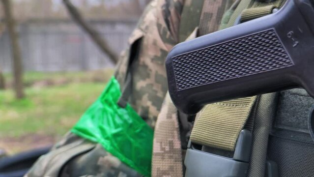 Soldier in camouflage uniform and with weapons in his hands - Close-up. Ukrainian army soldier in pixel camouflage and with close-up weapons.