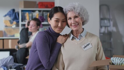 Portrait of multiethnic volunteers smile and hug looking at camera - Powered by Adobe
