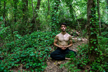 Naklejka na ściany i meble boy doing yoga in the woods