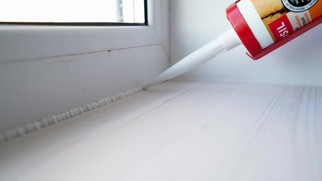 Worker Fills Window And Sill Connection With Acrylic Sealant