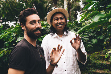 Half length portrait of happy male colleagues holding caffeine beans and smiling at camera during...