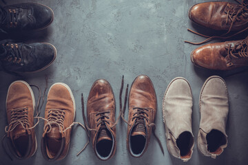 Old leather boots on  cement floor background texture. Old shabby boot shoes