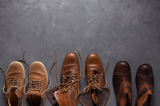 Old leather boots on  cement floor background texture. Old shabby boot shoes