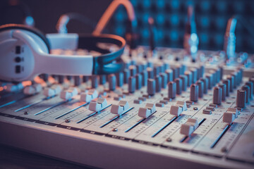 Headphones on sound mixer with faders and music cable jack. Audio equipment in record studio