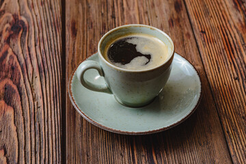 Mug of hot coffee on a wooden board