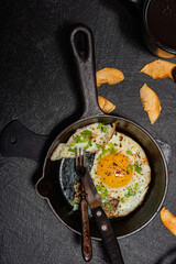 Fried egg in a cast-iron frying pan. Breakfast - kitchen utensils