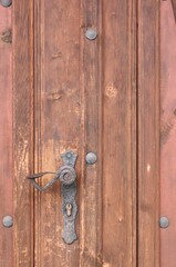 Wooden craft textured surface of the enter cottage door with different silver cruft metallic element as a comfortable background with different grungy structures. 