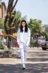 spring street fashion girl in white sweatshirt and jeans