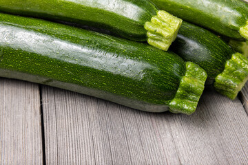 Fresh organic zucchini squashes on wooden background.