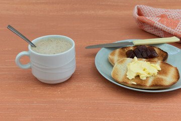 Taza de café y tostada con mantequilla y mermelada