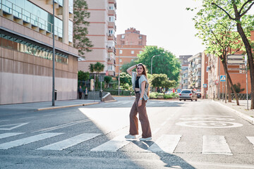 teenage woman crossing the street at a pedestrian crossing