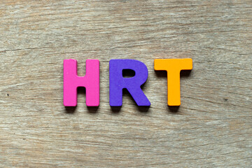 Color alphabet letter in word HRT (Abbreviation of Hormone replacement therapy) on wood background