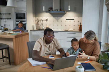 Portrait of multiethnic family with two children in casual home scene, copy space