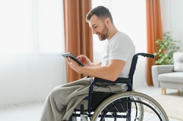 Fototapeta na wymiar Modern young disabled man in wheelchair having video call.