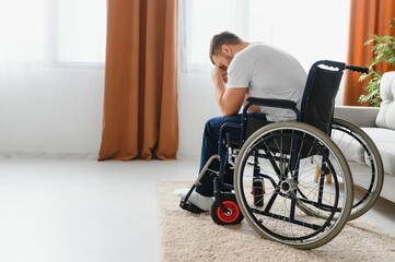 Depression and loneliness in disabled man. Elderly man in wheelchair crying indoors.