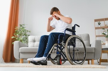 Depression and loneliness in disabled man. Elderly man in wheelchair crying indoors.