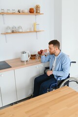 Fototapeta premium Young Disabled Man On Wheelchair In The Kitchen.